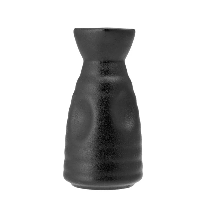 Bottiglia nera opaca dalla forma leggermente irregolare con base più larga e collo stretto, su sfondo bianco.