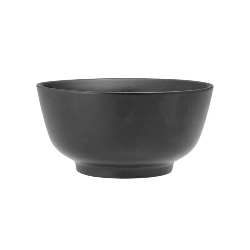Ciotola di colore nero, forma rotonda con base leggermente rialzata, materiali non specificati, sfondo bianco neutro.