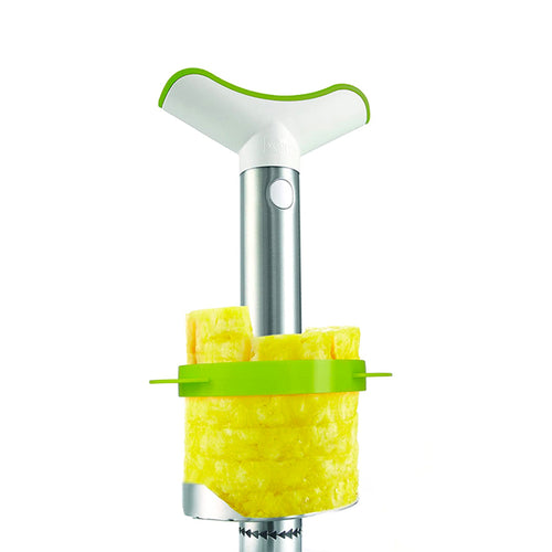 Utensile per ananas, con manico bianco e verde, corpo in metallo e fette di ananas giallo.