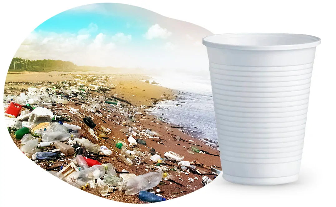 Spiaggia invasa da rifiuti di plastica di varie forme e colori con bicchiere di plastica bianco in primo piano