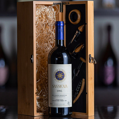 Bottiglia di vino rosso Sassicaia 1995 in vetro con tappo blu, in scatola di legno con accessori da vino e