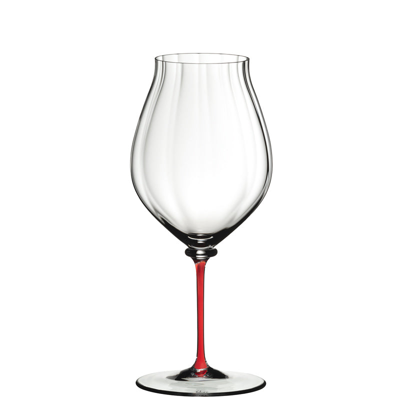 Calice da vino trasparente con stelo sottile di colore rosso, su sfondo bianco.