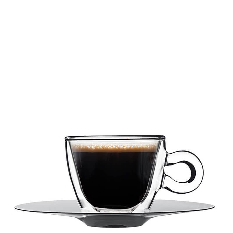 Café negro con espuma en cristal transparente sobre platillo redondo gris sobre fondo blanco