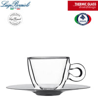 Taza transparente de cristal térmico con platillo metálico gris sobre fondo blanco