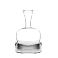 ampolla di vetro trasparente con collo stretto e base larga posizionata su un cilindro trasparente con texture a righe verticali, sfondo bianco