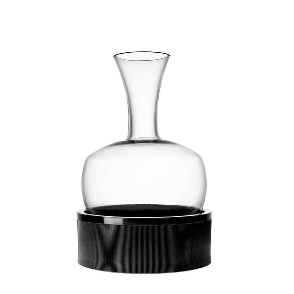 Caraffa trasparente in vetro con base cilindrica nera testurizzata, su sfondo bianco neutro.