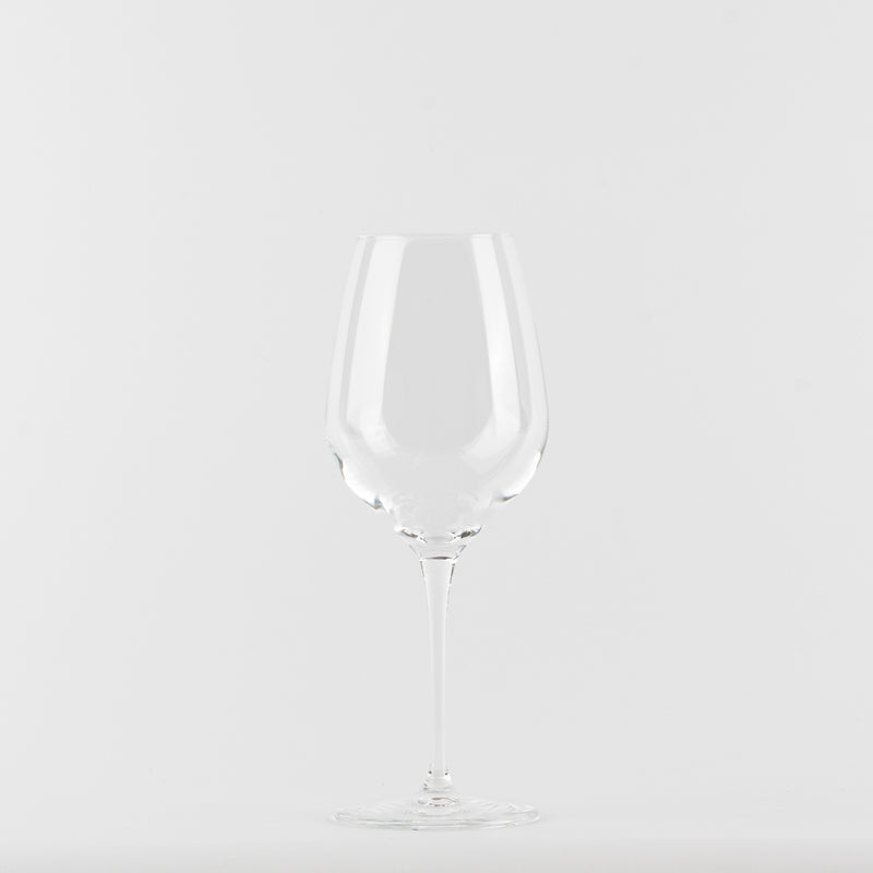 Bicchiere da vino trasparente in vetro con gambo lungo e base rotonda su sfondo bianco.
