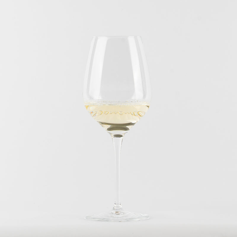 calice di vetro trasparente con vino bianco chiaro su sfondo bianco neutro