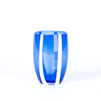 bicchiere alto di vetro blu con due strisce verticali bianche su sfondo bianco