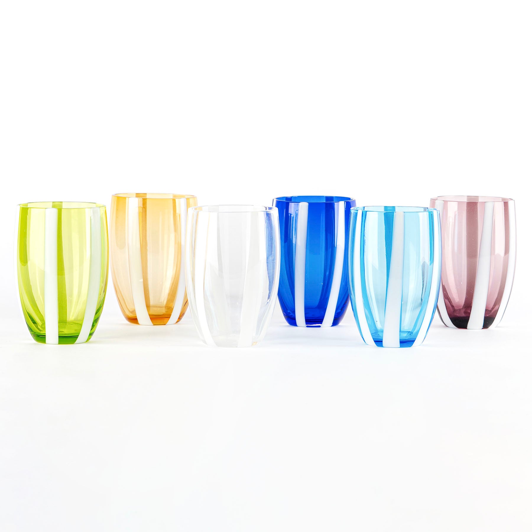 sei bicchieri trasparenti di vetro colorati con strisce bianche verticali, disposti su sfondo bianco, colori verde, arancione, trasparente, blu