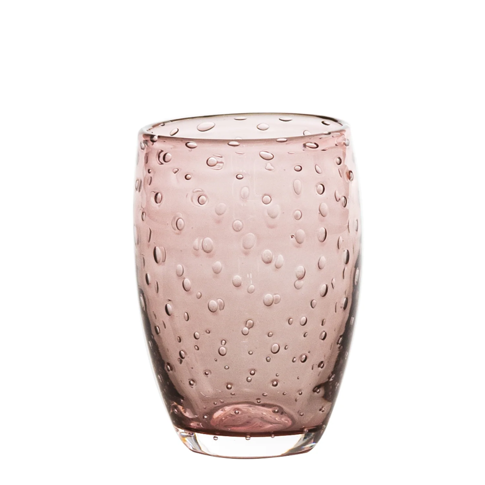 Bicchiere rosa trasparente con bolle in rilievo su tutta la superficie, forma leggermente arrotondata, sfondo bianco.