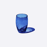 bicchiere blu in vetro trasparente con bolle, forma cilindrica arrotondata, ombra sul lato destro, sfondo bianco